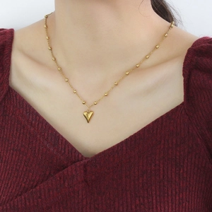 Elegante goldene Herzanhänger-Halskette an einer Perlenkette, getragen am Hals