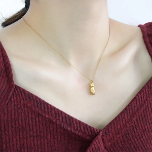 Künstlerische Frauenkörper-Anhänger-Halskette in Gold-Finish an Modell mit rotem Strick