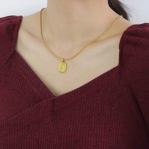 Detailansicht eines Sonnenblumen-Reliefanhängers an einer goldenen Kordelkette