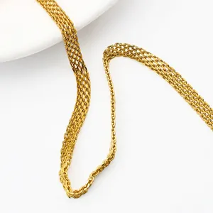 Detail of gold woven mesh chain with multi-row metallic texture on a white plate