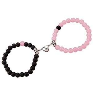 Dettaglio della chiusura magnetica a cuore tra i bracciali di perle rosa e nere