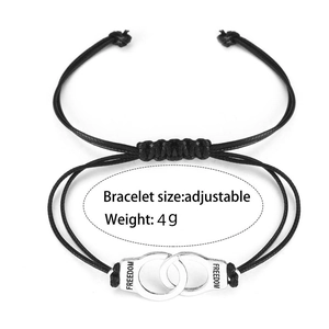 Detail of adjustable black woven bracelet with silver handcuffs and Freedom engraving