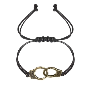 Detail of adjustable black woven rope bracelet with gold freedom handcuff charm