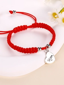 Close-up of red braided rope bracelet with silver heart pendant engraved with Mom text