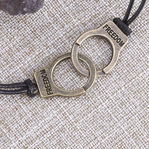 Macro detail of bronze handcuffs bracelet with Freedom engraving on burlap