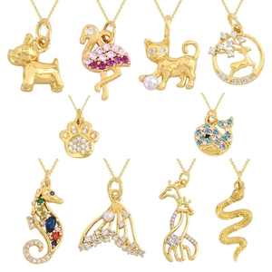 Vue macro de pendentifs animaux dorés avec zircons colorés et détails en perles