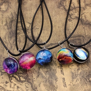 Detail view of five galaxy themed glass sphere pendants with various cosmic nebula patterns