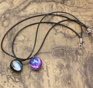 Detailed macro of vintage galaxy pendant with nebula glass dome on a retro map background