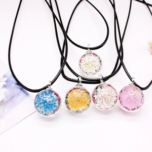 Handmade forest-style necklaces with real dried flowers in glass spheres on black cords