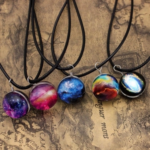 Detailed display of assorted double-sided galaxy glass orb pendants on vintage map