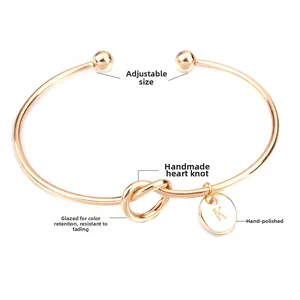 Détail du bracelet noeud doré réglable avec un pendentif rond à la lettre K
