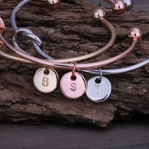 Vue détaillée de bracelets à nœuds avec pendentifs lettres en or, argent et or rose