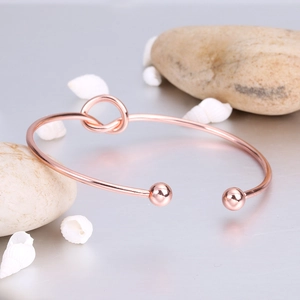 Minimalist knot-design rose gold open cuff bracelet with spherical ends and smooth finish