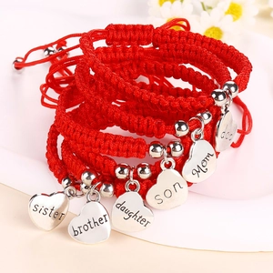 Handmade red cord bracelets with silver heart charms for family members on white background