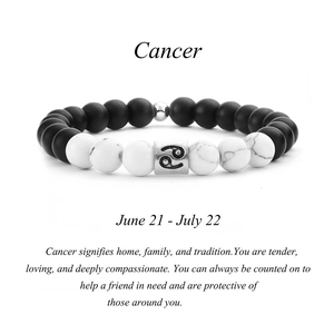 Détail d'un bracelet en perles de pierre marbre noir et blanc avec breloque signe Cancer