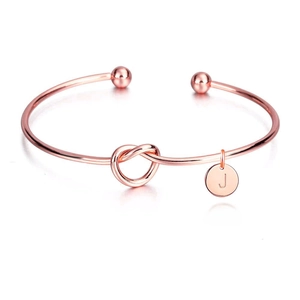 Détail du bracelet noeud en or rose avec un pendentif lettre J personnalisé