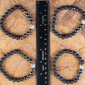 Detailopname van 8mm lavasteen en tijgeroog armbanden met liniaal voor afmetingen
