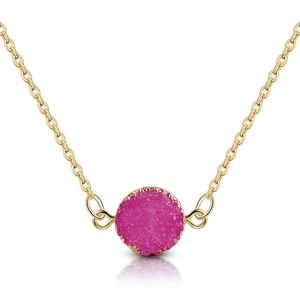 Gros plan sur collier doré avec pendentif rond en cristal druzy magenta et chaîne délicate