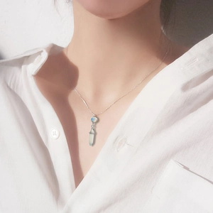 Elegant silver necklace with white round gemstone and light blue crystal prism pendant