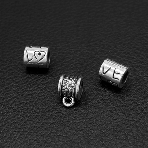 Vista macro di ciondoli in argento vintage con incisione LOVE e motivi a rilievo su pelle