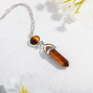 Macro shot of tiger eye stone pendant featuring a hexagonal pillar and round silver chain