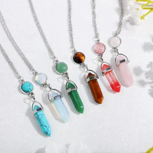 Hexagonal crystal column necklace set with natural gemstones on a white textured fabric