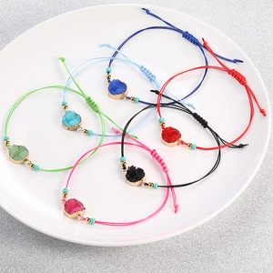 Set di braccialetti di cristallo intrecciati a mano in sei colori su un piatto bianco