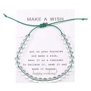 Dettaglio del bracciale dei desideri intrecciato verde regolabile con perline e cuore