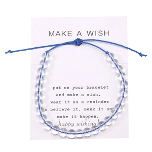 Dettaglio del bracciale fatto a mano in perle di cristallo 6mm con cordino blu su carta