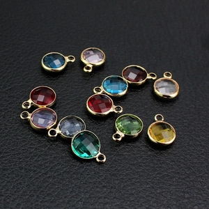 Close-up of assorted multi-colored round faceted birthstone pendants with gold frames