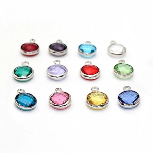 Detailed macro view of twelve colorful round faceted birthstone pendants for DIY jewelry