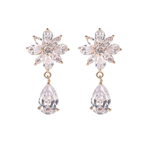 Detalle de pendientes de flor dorados con pétalos de circón y cristales de gota transparentes