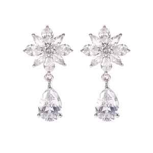 Primer plano de pendientes florales con brillantes circonitas en forma de gota y marquesa