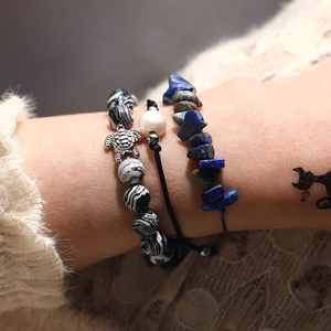 Nahaufnahme der handgefertigten Schildkröten-Armbänder mit blauen Steinen und Perle