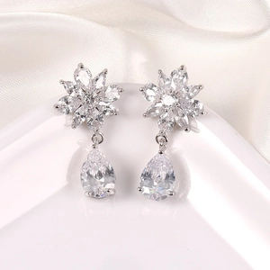 Detalle de pendientes de flor plateados con colgante de gota en circonita blanca