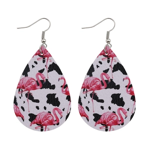 Detailed macro view of teardrop leather earrings with flamingo and cow print patterns