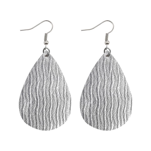 Detail showing silver teardrop earrings with textured wave patterns and fishhook clasps