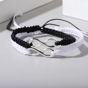 Detail der minimalistischen gewebten Unendlichkeitsarmbänder in Schwarz und Weiß mit Silber