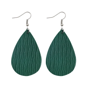 Detailed close-up of dark green teardrop faux leather earrings with lychee texture