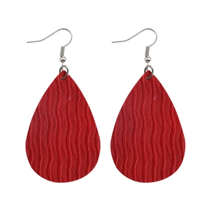 Detailed macro view of red water drop earrings with wave-textured faux leather patterns