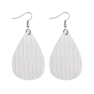 Detailed macro of white teardrop PU leather earrings with textured wave pattern