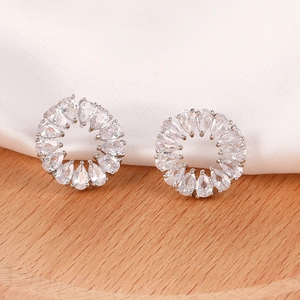 Detalle macro de pendientes de corona floral en plata con circonitas de pera