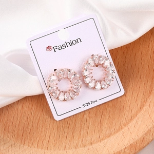 Detalle de pendientes de aro en oro rosa con circonitas y agujas de plata S925 en raso blanco