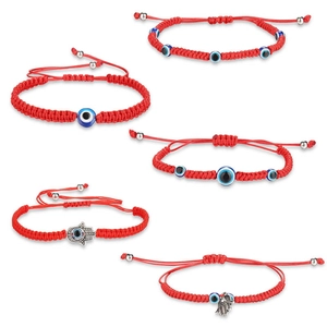 Details van rode gevlochten armbanden met boze oog en hand van Fatima bedels en knopen