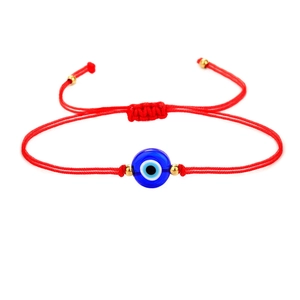 Detail van rode Evil Eye armband met blauwe kraal en gouden metalen accenten