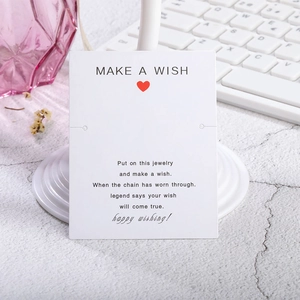 Primer plano de tarjeta para joyas Make a Wish blanca con corazón rojo y texto motivador