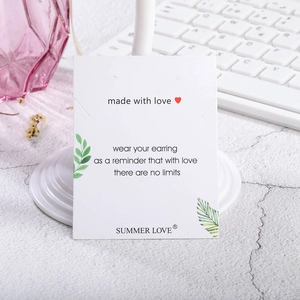 Detalle de tarjeta blanca para joyas con motivo de hojas y texto inspirador