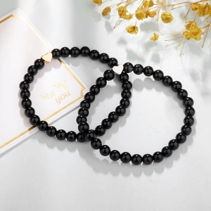 Detail van 6mm zwarte agaat kralenarmbanden met goud en zilveren hartjes als cadeau