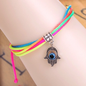 Detailopname van geweven Hamsa-armband met kleurrijk koord en blauw boze oog detail