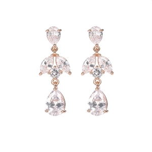 Detalle de pendientes en oro rosa con circonitas en capas y diseño de gota de agua elegante